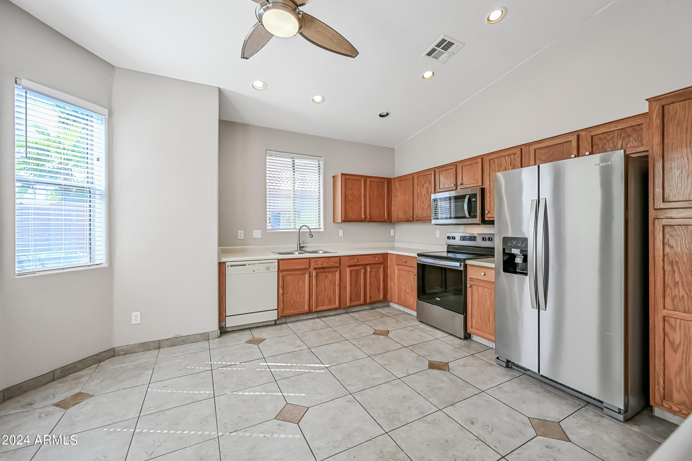 6707 East Roland Street Mesa, AZ 85215 - Photo 9 of 32 a kitchen with stainless steel appliances granite countertop a refrigerator and a sink