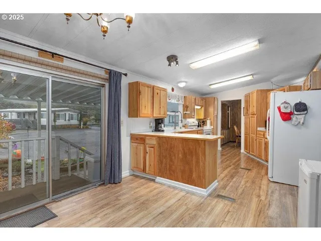 a kitchen with stainless steel appliances granite countertop a refrigerator a sink and a stove