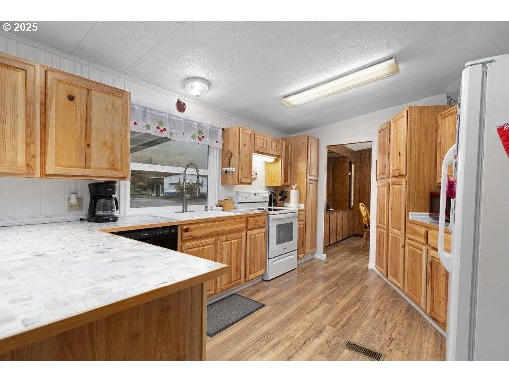 406 Shadow Ranch Lane Roseburg, OR 97470 - Photo 12 of 32 a kitchen with stainless steel appliances granite countertop a refrigerator a sink and a stove