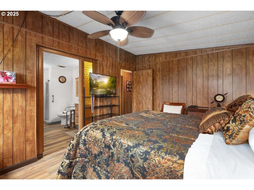 406 Shadow Ranch Lane Roseburg, OR 97470 - Photo 21 of 32 a bedroom with a bed and a large mirror with a flat tv screen