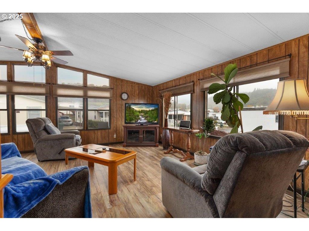 406 Shadow Ranch Lane Roseburg, OR 97470 - Photo 7 of 32 a living room with furniture a flat screen tv and a floor to ceiling window