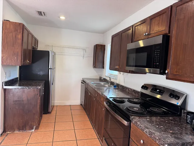 a kitchen with stainless steel appliances a stove microwave and refrigerator