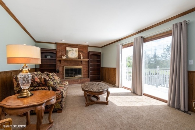 3561 Ronald Road Crete, IL 60417 - Photo 7 of 18 a living room with furniture a fireplace and a large window
