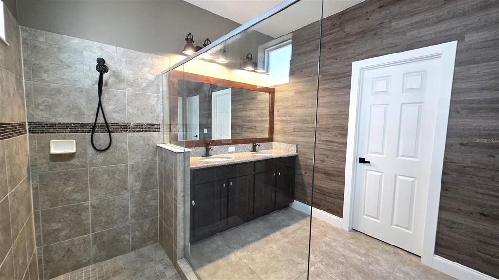 5531 Cypress Hill Road Winter Garden, FL 34787 - Photo 24 of 62 a bathroom with a double vanity sink a mirror and a shower