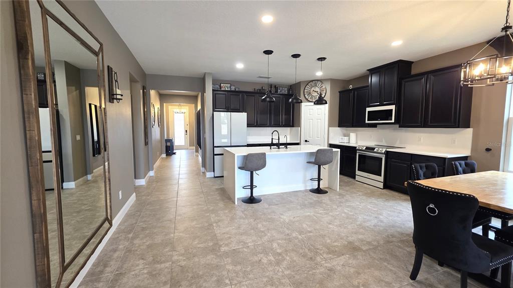 5531 Cypress Hill Road Winter Garden, FL 34787 - Photo 7 of 62 a large white kitchen with cabinets chairs and refrigerator
