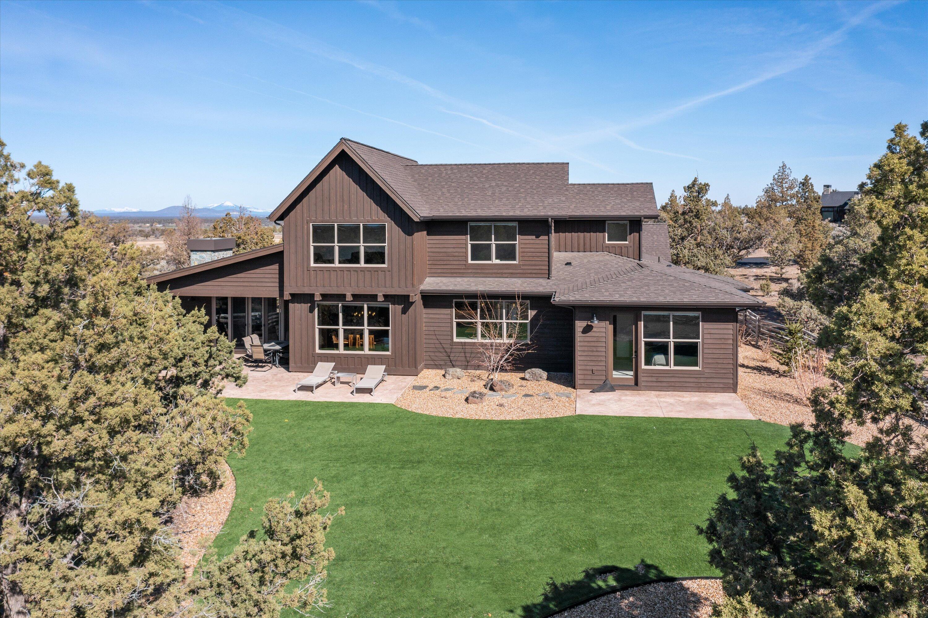 15687 Southwest Brasada Rnch Road Powell Butte, OR 97753 - Photo 1 of 73 a front view of a house with a garden and trees