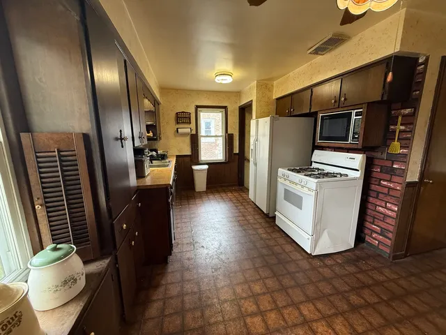 a kitchen with a sink a stove top oven and cabinetry