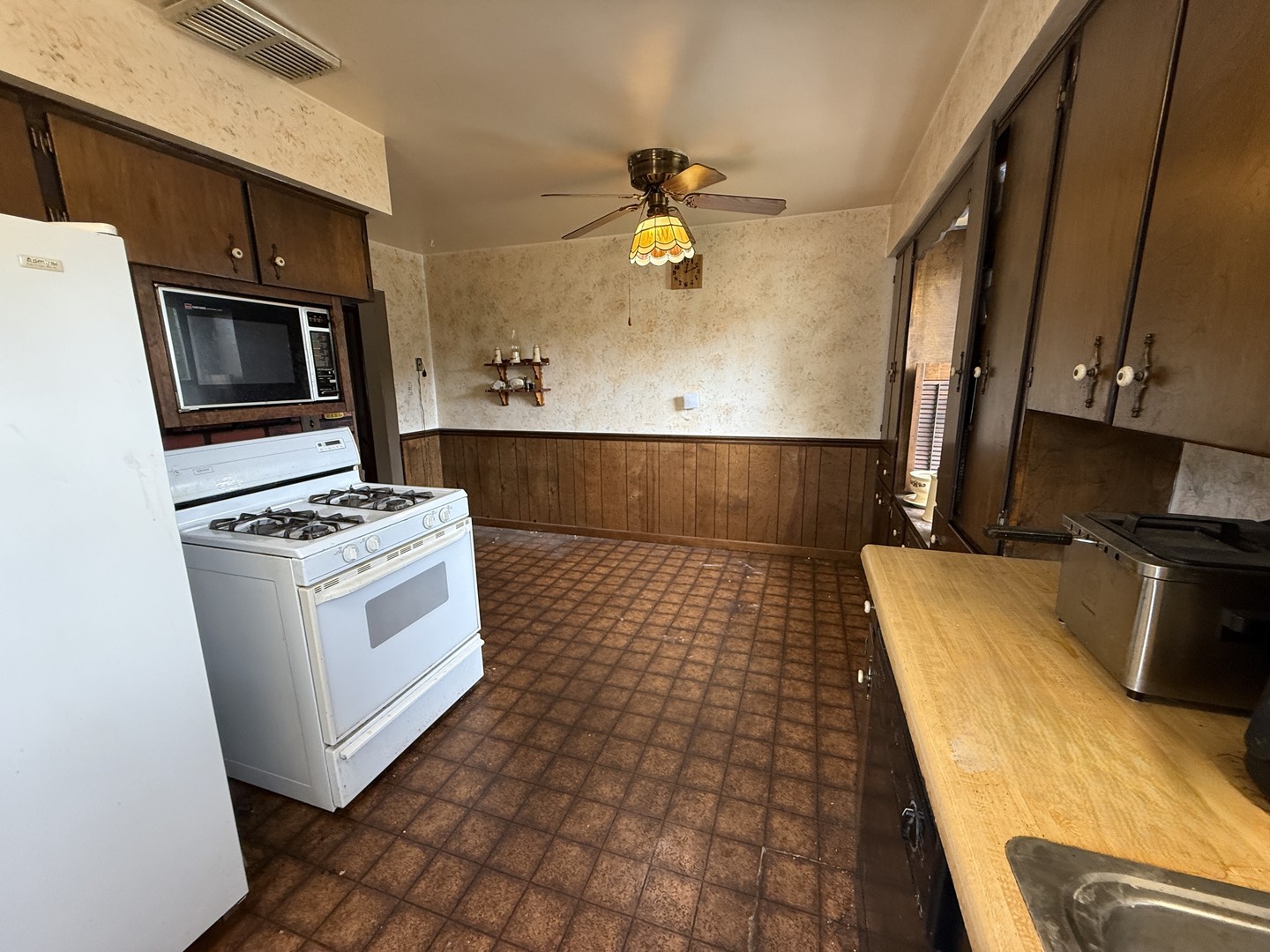18316 Sherman Street Lansing, IL 60438 - Photo 7 of 14 a kitchen with a sink a stove top oven and cabinetry
