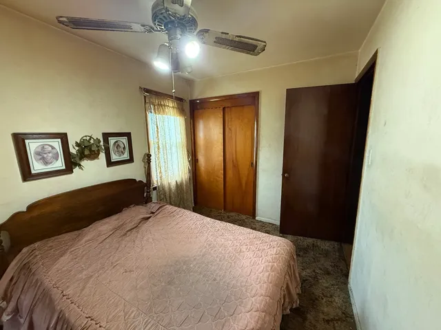 a bedroom with a bed window and a flat screen tv