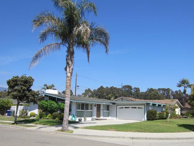 a view of a house with a yard and potted plants