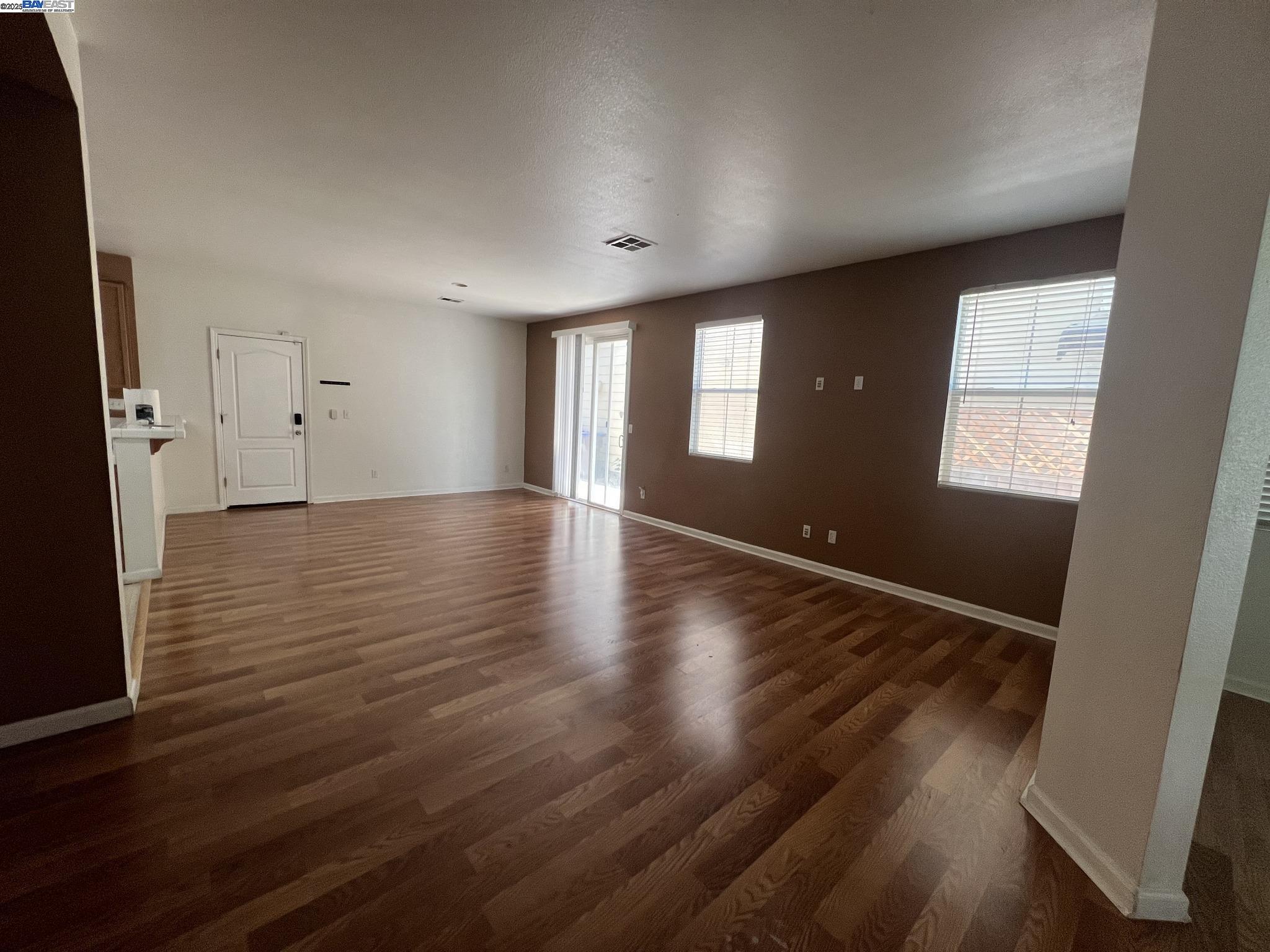 3127 Puffin Circle Fairfield, CA 94533 - Photo 2 of 23 an empty room with wooden floor and windows
