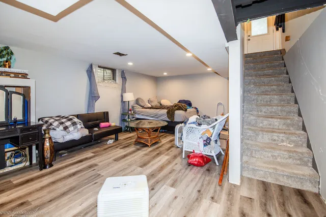 a white bench sitting in a yard with plants and large trees