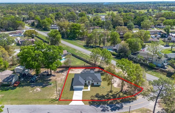 an aerial view of a house with a yard and lake view