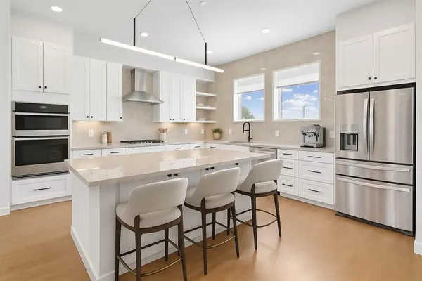 a kitchen with stainless steel appliances white cabinets and a refrigerator