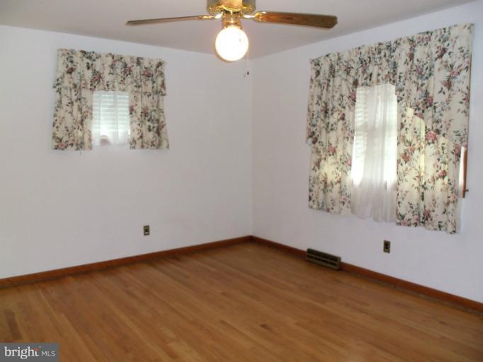 8010 Sagramore Road Rosedale, MD 21237 - Photo 2 of 14 a view of an empty room with a window and wooden floor