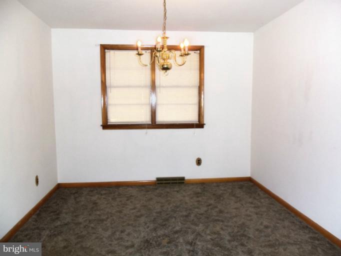 8010 Sagramore Road Rosedale, MD 21237 - Photo 9 of 14 an empty room with window and chandelier fan