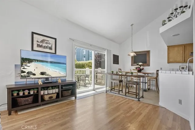 a dining hall with stainless steel appliances granite countertop a stove top oven a sink with granite countertops and couches with wooden floor