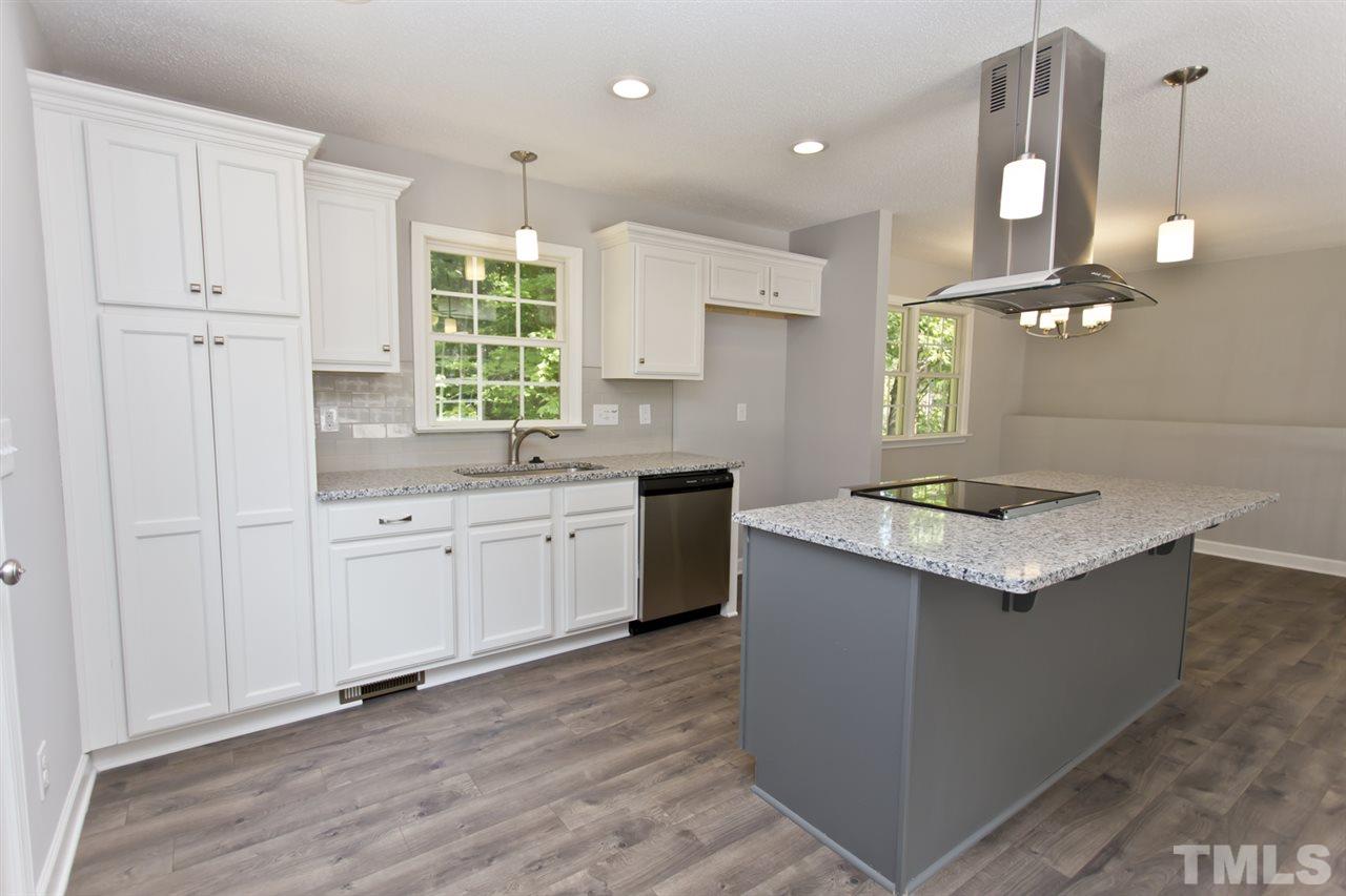 317 East Pilot Street Durham, NC 27707 - Photo 4 of 30 a kitchen with stainless steel appliances granite countertop a sink a stove and a wooden floors