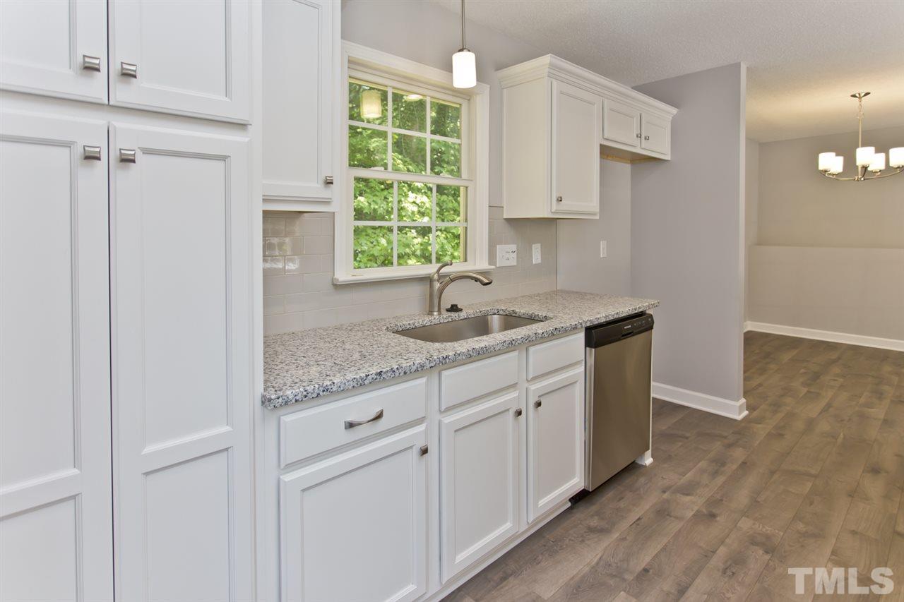 317 East Pilot Street Durham, NC 27707 - Photo 6 of 30 a kitchen with white cabinets and sink