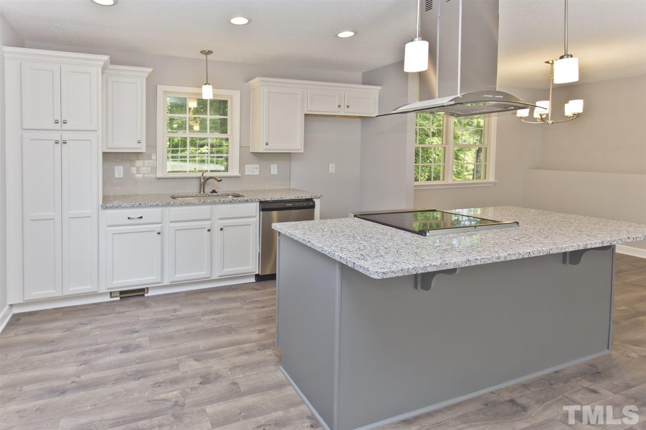 317 East Pilot Street Durham, NC 27707 - Photo 7 of 30 a kitchen with kitchen island granite countertop a stove a sink a center island and cabinets