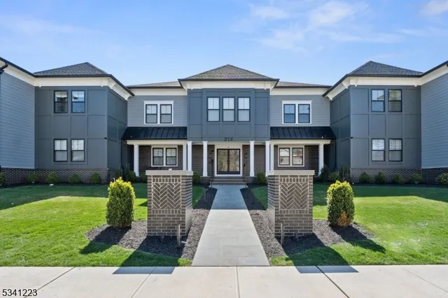 a front view of a house with garden and trees