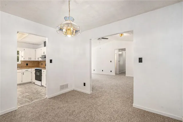 a view of a kitchen with refrigerator and wooden cabinets