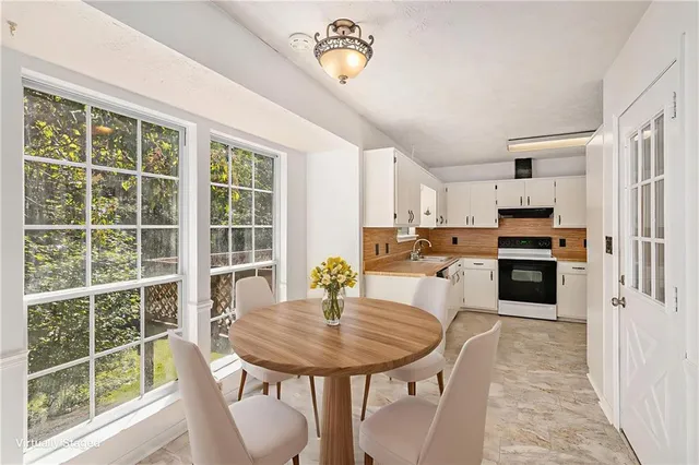 a kitchen with a table chairs refrigerator and microwave
