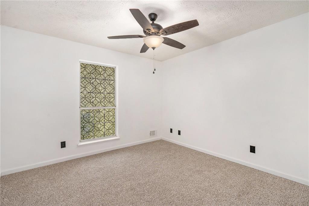 551 Hood Road Stockbridge, GA 30281 - Photo 22 of 49 an empty room with ceiling fan and window