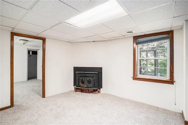 an empty room with windows and fireplace