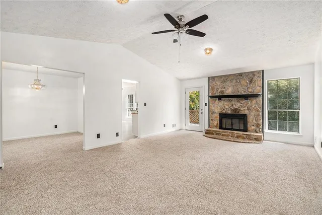 a view of an empty room with a fireplace and a window