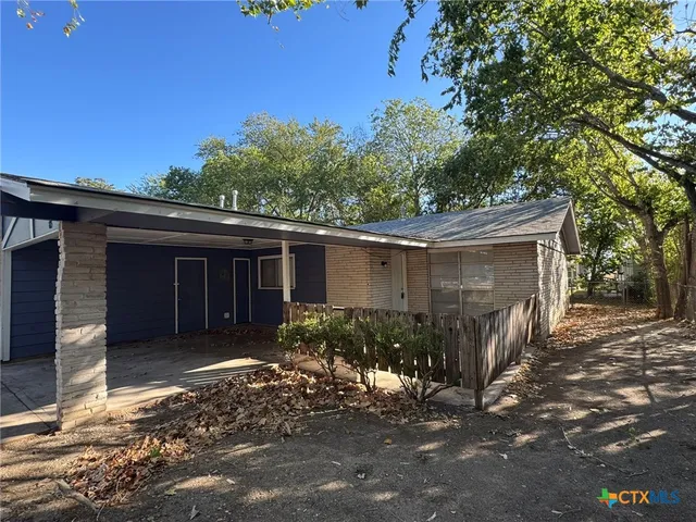 a view of a house that has tree in front of it