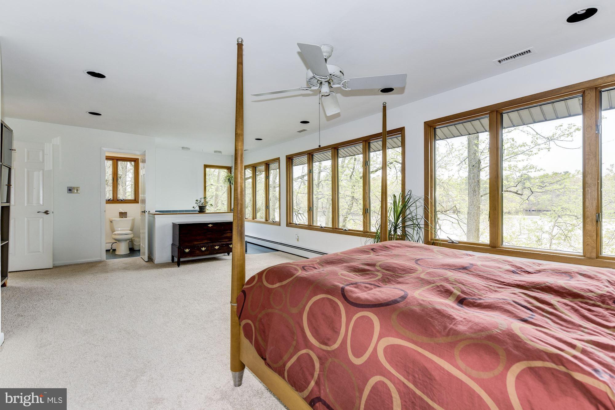 8 Robinson Road Medford, NJ 08055 - Photo 42 of 55 a spacious bedroom with a large bed and a chandelier