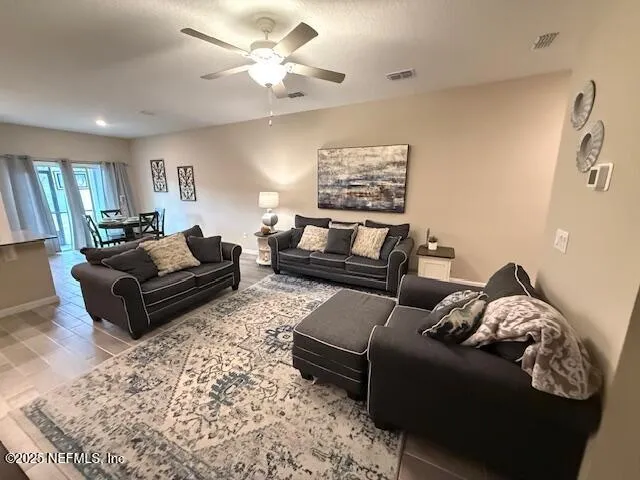 a living room with furniture ceiling fan and a rug