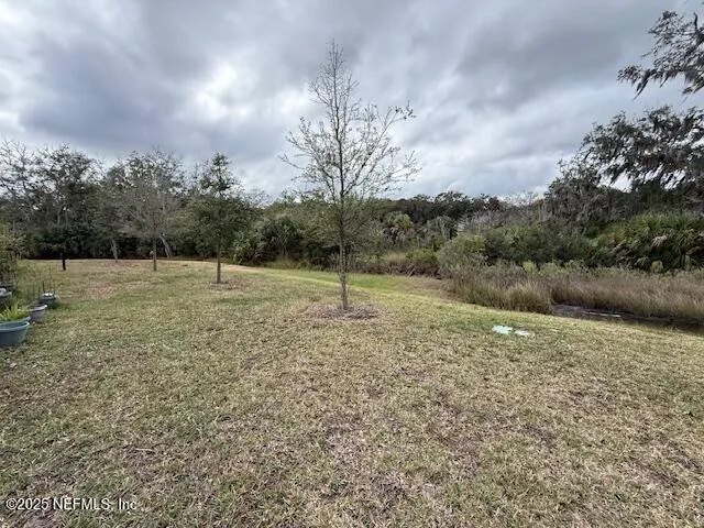 a view of a field with trees in the background