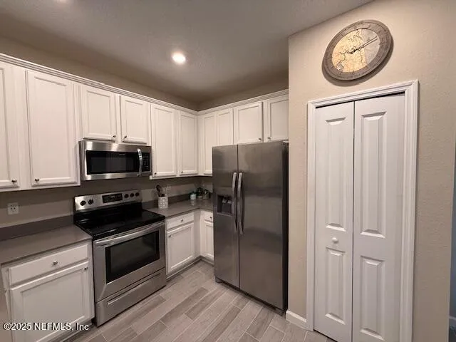 a kitchen with a refrigerator a stove and cabinets