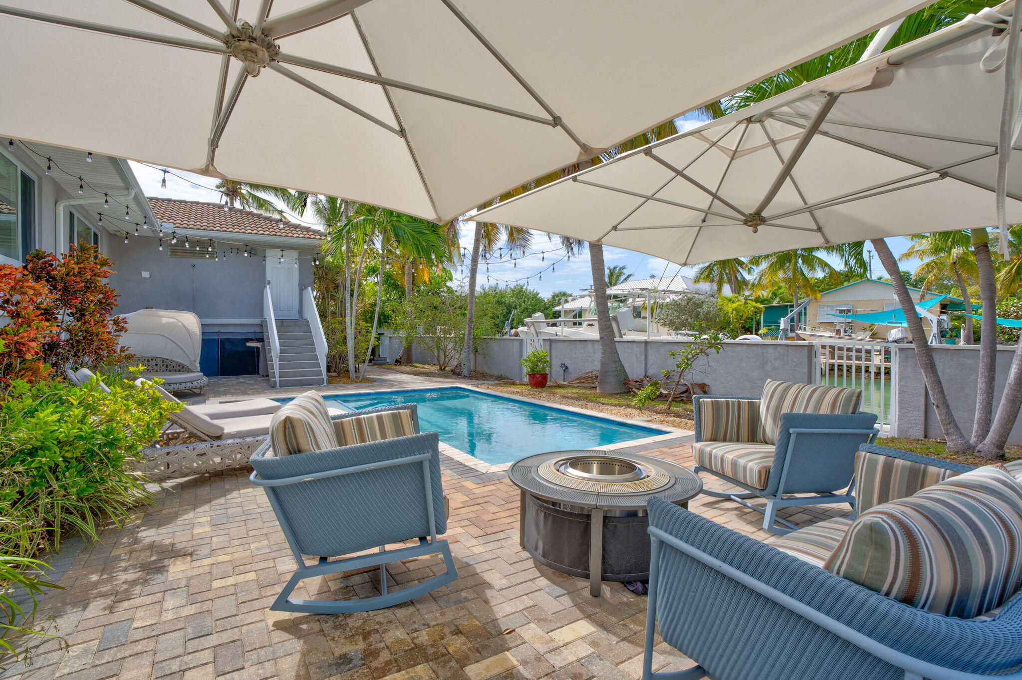 56 Colson Drive Cudjoe, FL 33042 - Photo 24 of 50 a view of a patio with couches table and chairs under an umbrella