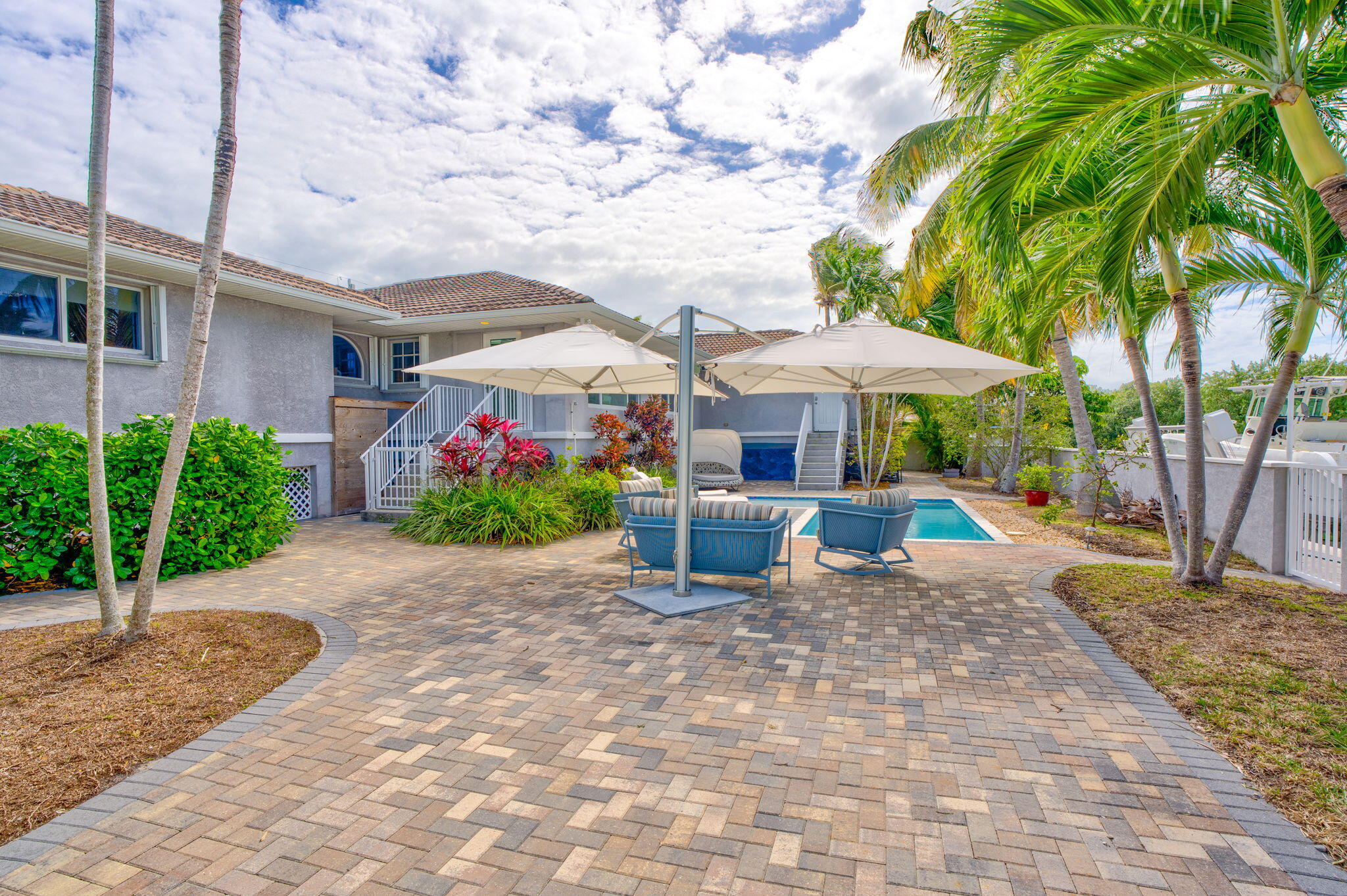 56 Colson Drive Cudjoe, FL 33042 - Photo 27 of 50 a lawn chairs under an umbrella in front of house