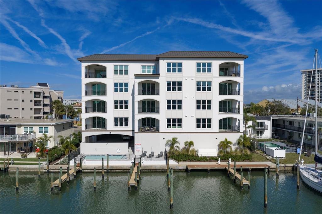 211 Dolphin Point, Unit 1 Clearwater Beach, FL 33767 - Photo 12 of 16 a roof deck with table and chairs and potted plants