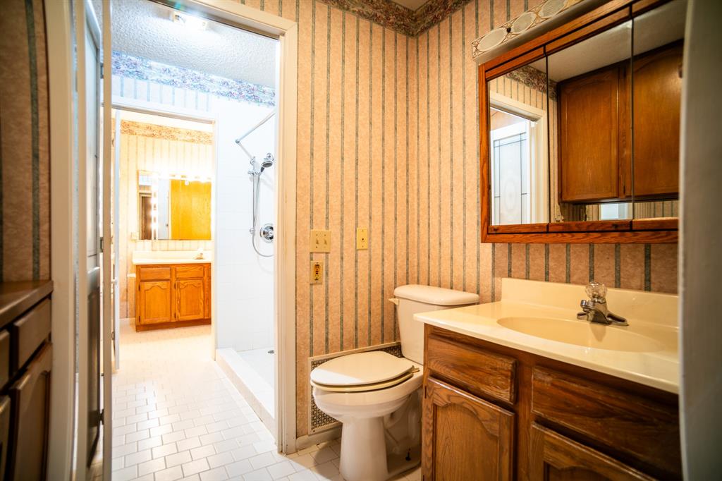 8312 Llano Avenue Benbrook, TX 76116 - Photo 16 of 40 a bathroom with a sink a toilet and a mirror