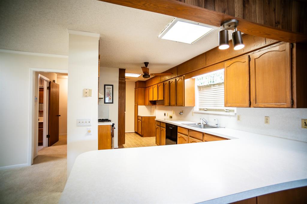 8312 Llano Avenue Benbrook, TX 76116 - Photo 19 of 40 a large kitchen with stainless steel appliances wooden floor and a refrigerator