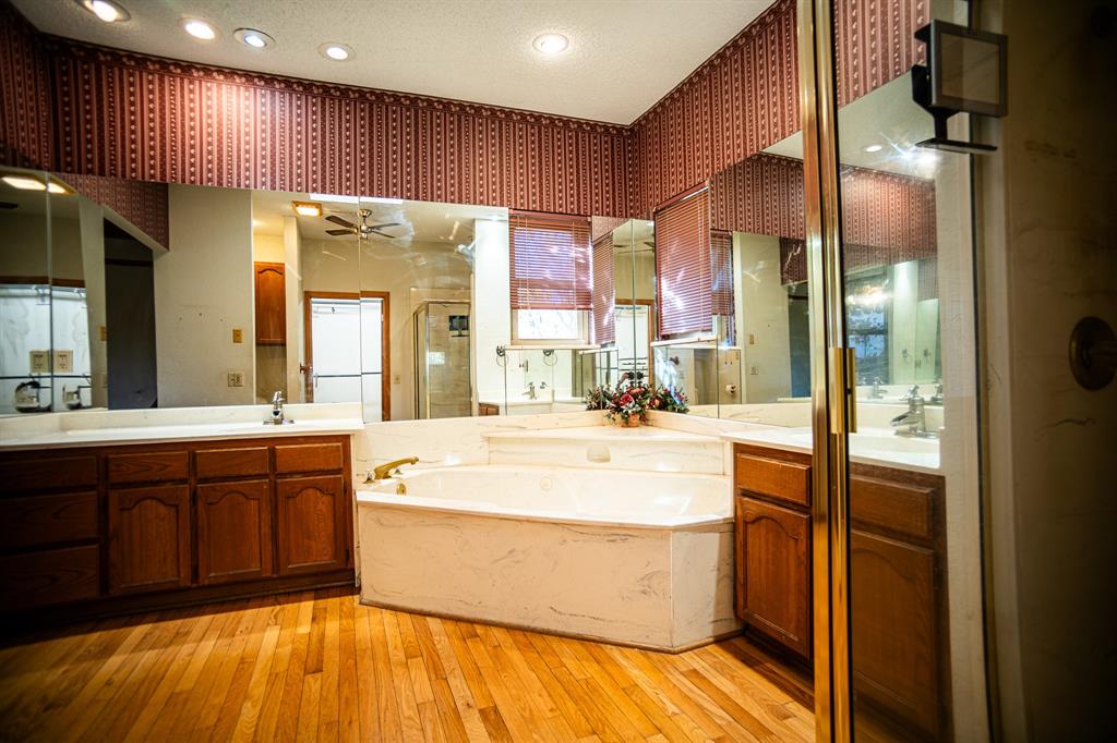 8312 Llano Avenue Benbrook, TX 76116 - Photo 25 of 40 a large bathroom with a large tub a sink shower and a mirror