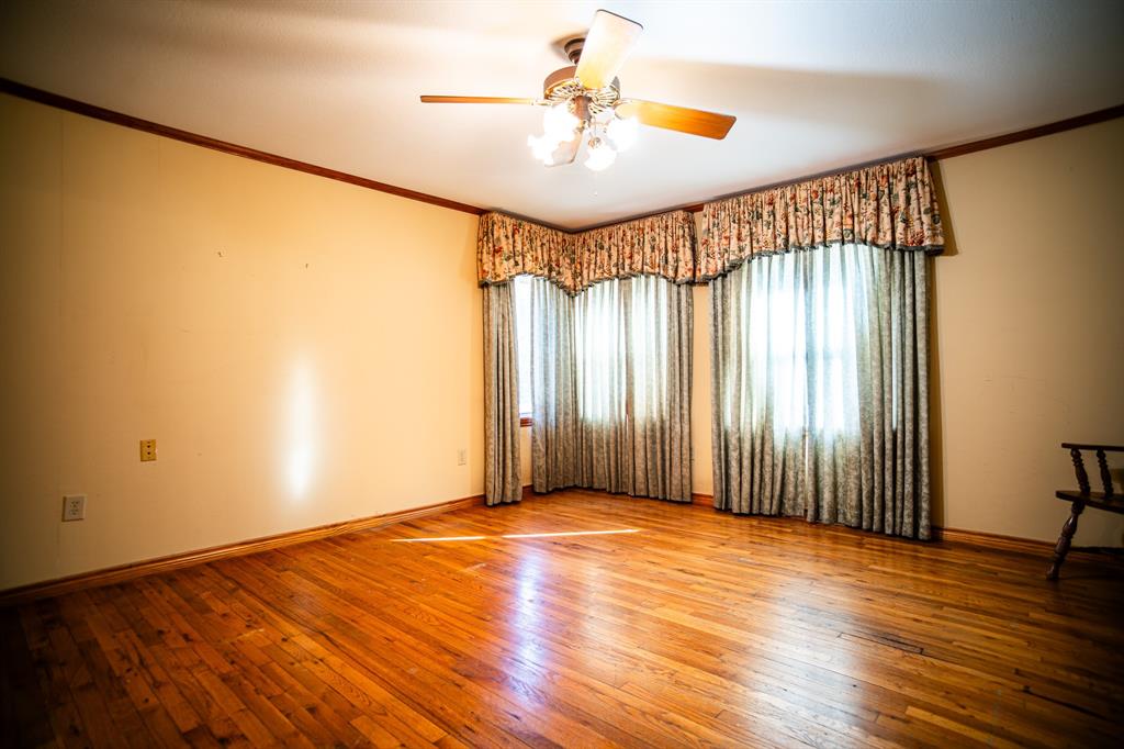 8312 Llano Avenue Benbrook, TX 76116 - Photo 29 of 40 an empty room with wooden floor fan and windows