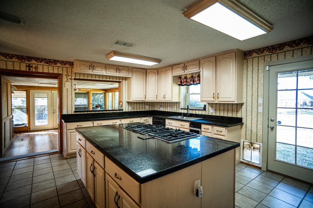 8312 Llano Avenue Benbrook, TX 76116 - Photo 34 of 40 a kitchen with a stove a sink and a refrigerator
