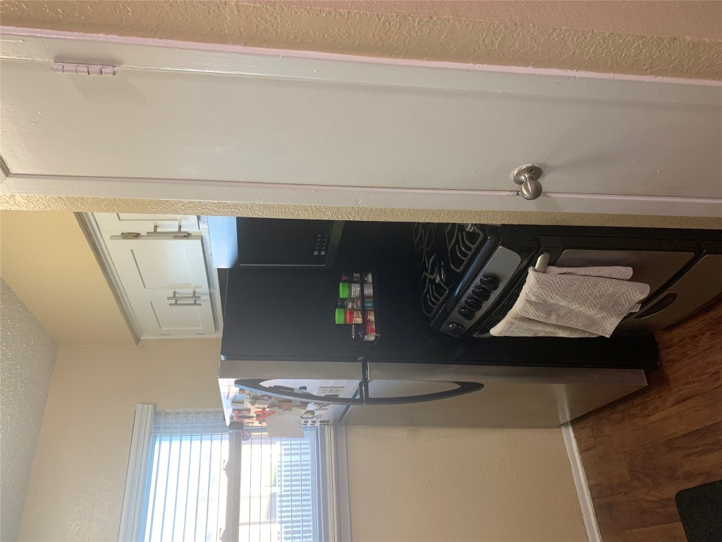2401 Manor Road, Unit 218 Austin, TX 78722 - Photo 7 of 8 a kitchen with appliances and a refrigerator