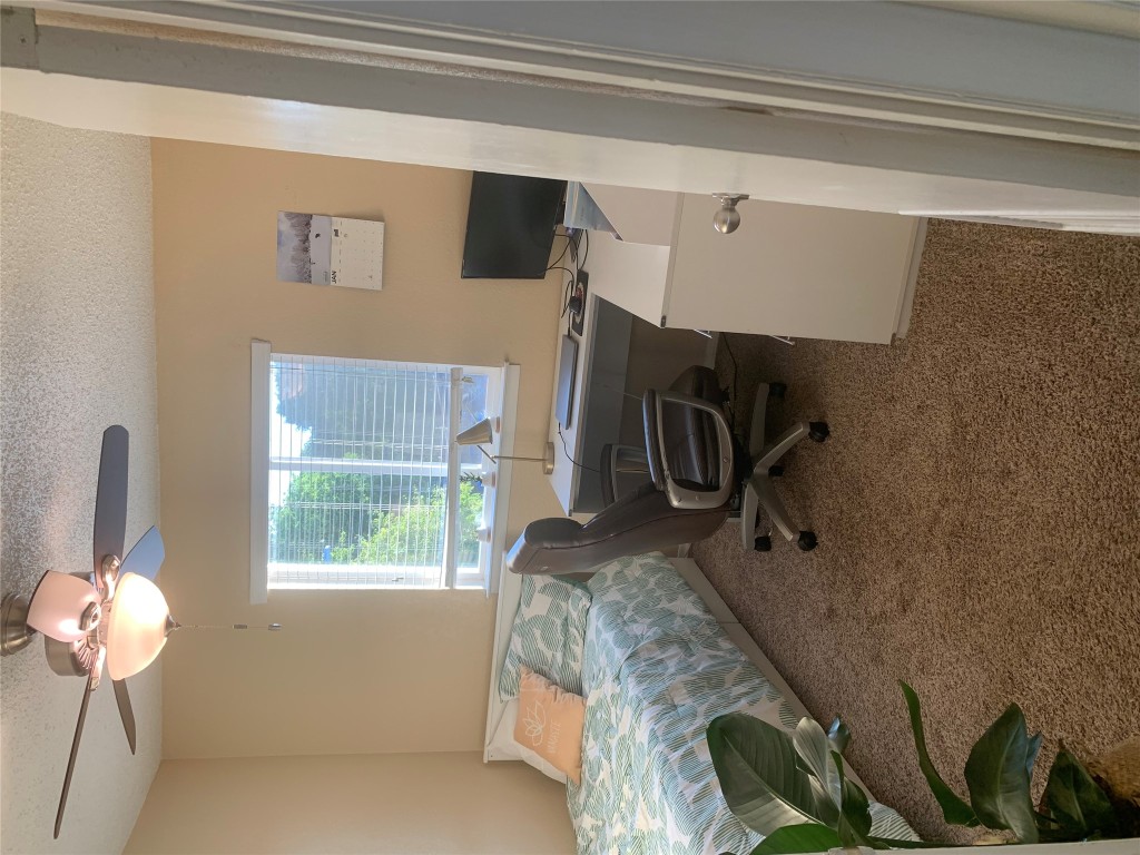 2401 Manor Road, Unit 218 Austin, TX 78722 - Photo 8 of 8 a bedroom with a bed and a chandelier