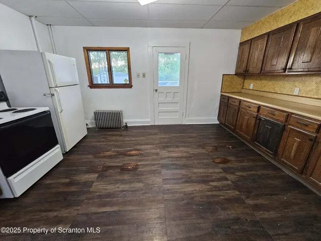 a view of a kitchen with wooden floor and a sink