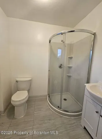 a bathroom with a toilet and a shower