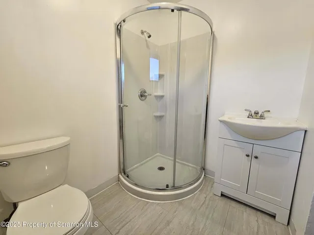a bathroom with a toilet a sink and shower