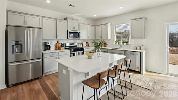 a kitchen with stainless steel appliances a microwave sink stove refrigerator and cabinets