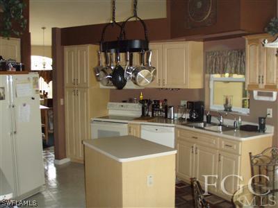 9167 Henry Road Fort Myers, FL 33967 - Photo 4 of 10 a kitchen with stainless steel appliances granite countertop a sink a stove and a refrigerator